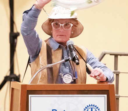 
			
				                                Auction Chair Jane Birckhead of Morrow, Ohio, touts the private fly fishing vacation prize during a recent Rotary Club meeting.
 
			
		